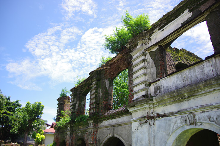 パオアイのサン・オウガスチン教会の隣にある草木が生い茂る廃墟の写真